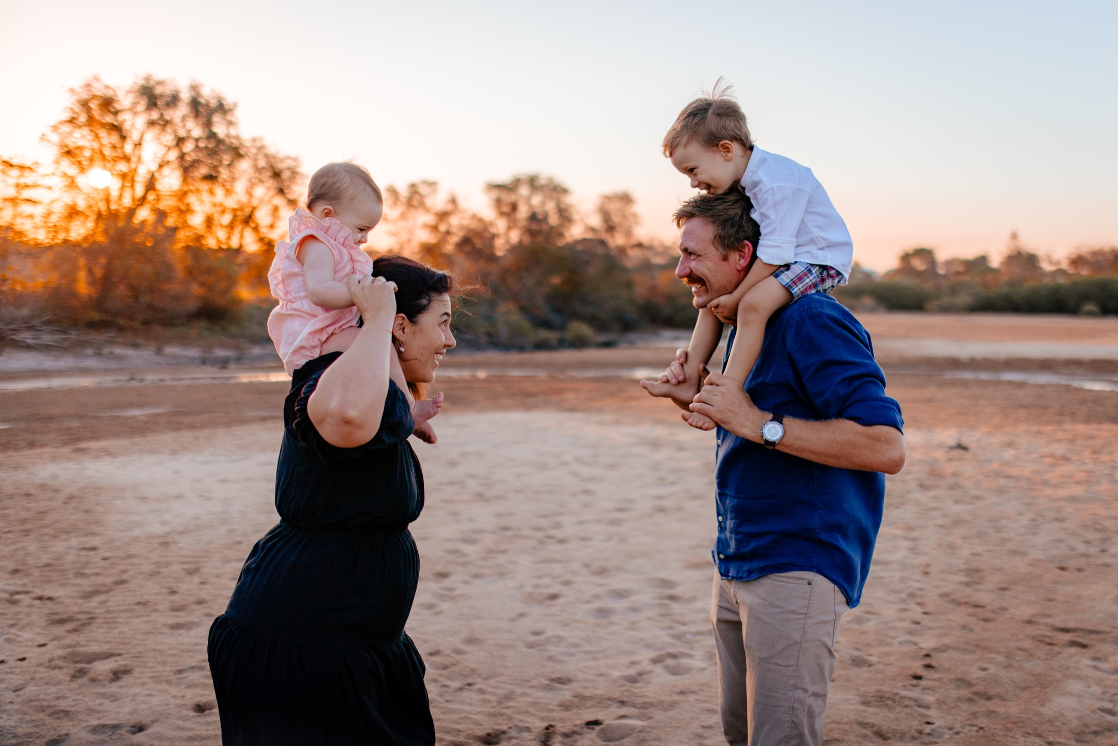 Family playing on a sandy riverbed at golden hour · Jamie Hall, Definitive Imaging