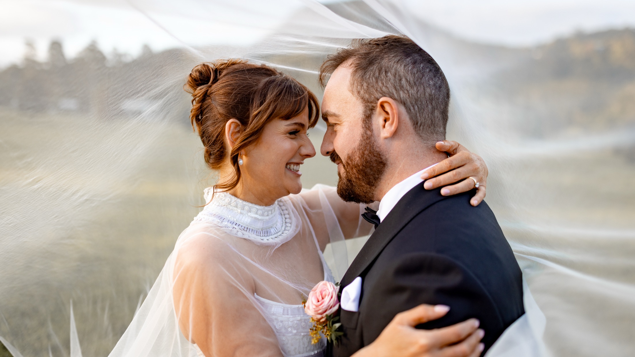 Bride and groom embracing under a flowing veil · Jamie Hall, Definitive Imaging